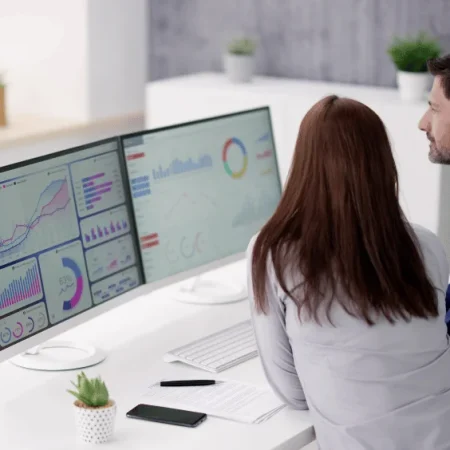 Zwei Personen diskutieren Online-Statistiken über Hosting, Webdesign und Marketing